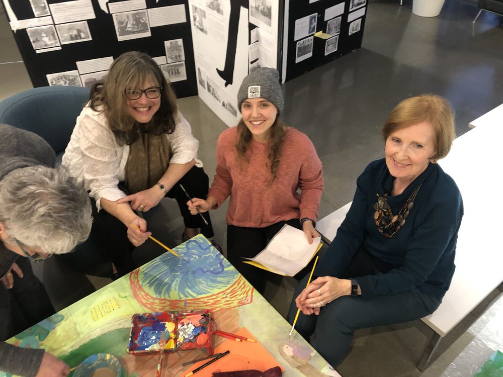 Participants painting a section of the mural