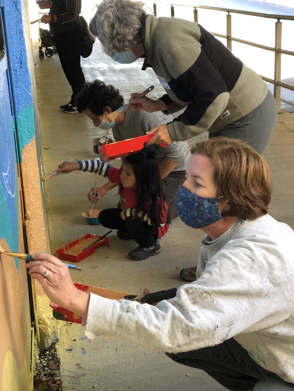 Contributors painting at the underpass wall