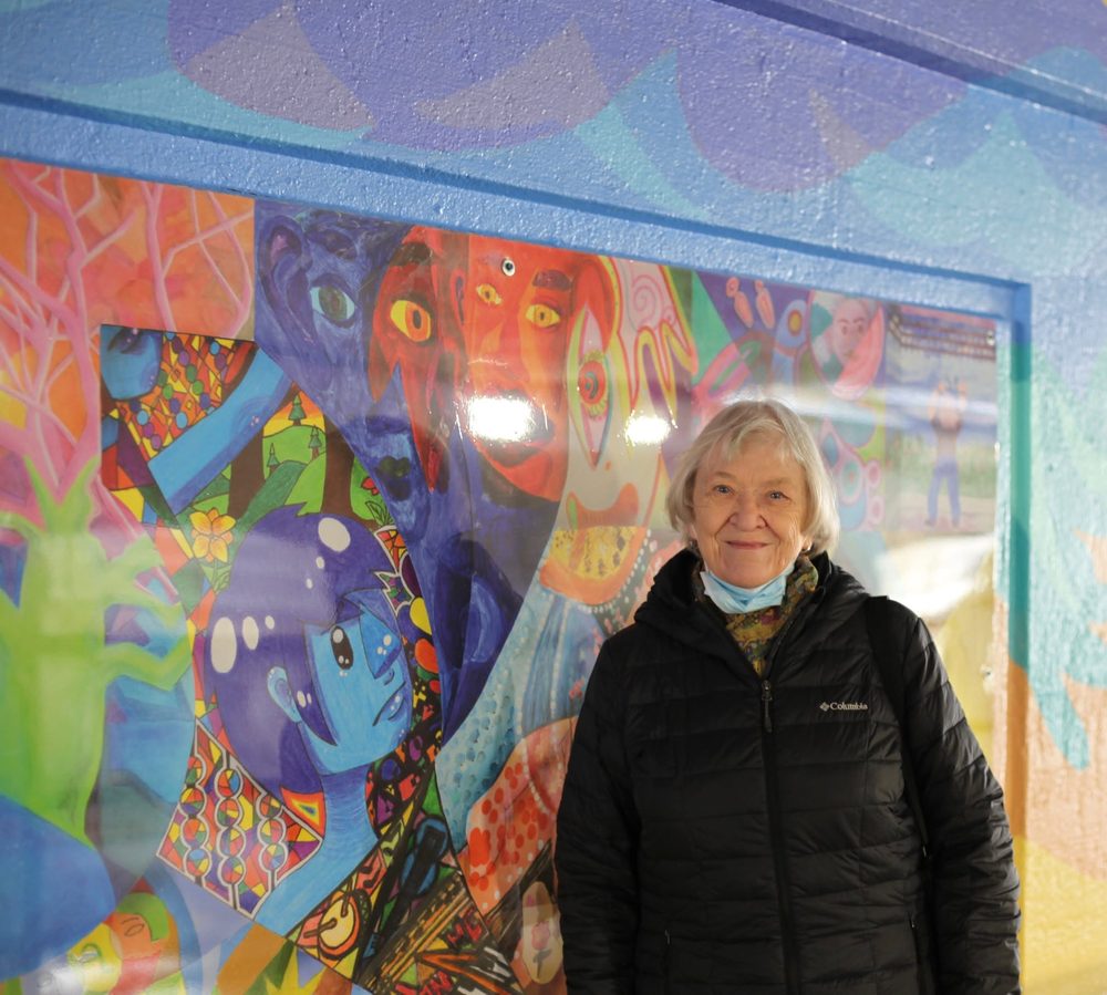 A contributor standing beside her panel