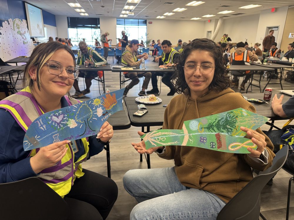 Two leaders holding the pieces they painted