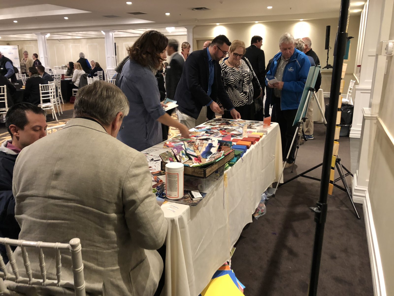 Conference guests at a long collage table in a hotel ballroom