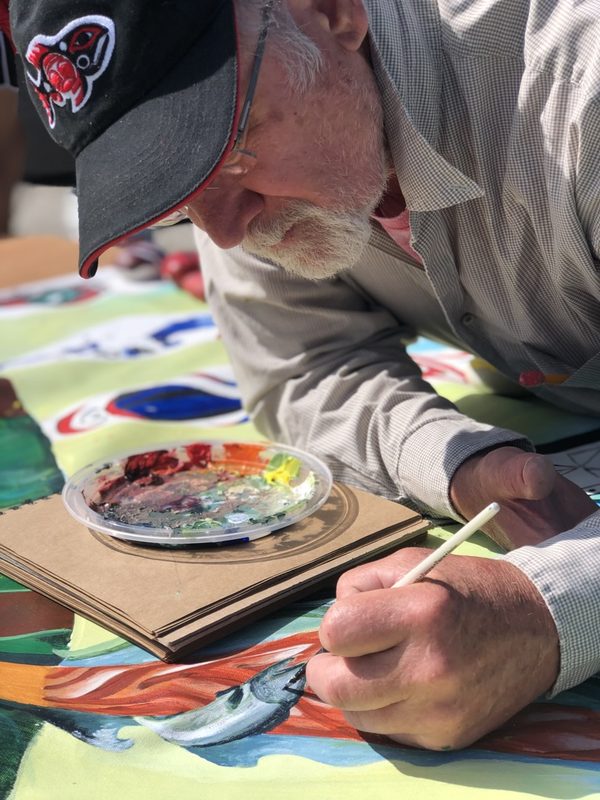 A guest painting at the Paddle to Lummi engagement booth