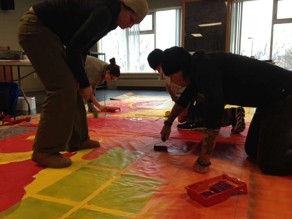 Participants painting on the floor