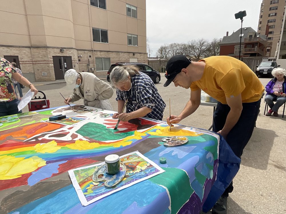 People painting a canvas outdoors